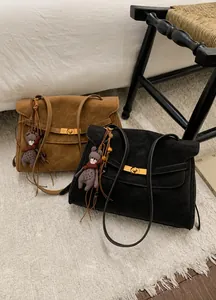 Detailansicht der Vintage Wildleder-Schultertaschen mit Metallschnallen und Bärenanhängern