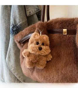 Ciondolo a forma di cane di peluche marrone con collare in metallo sulla borsa