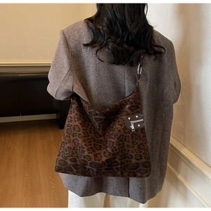 Detail view of large leopard print hobo bag with stylish metal studs and zipper trim