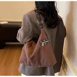 Detail of suede shoulder bag with silver studs on leather strap and zipper pocket