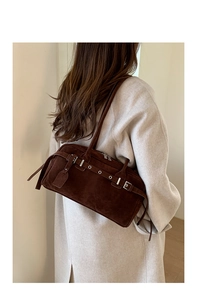 Detail view of dark brown suede shoulder bag with vintage silver metal buckles