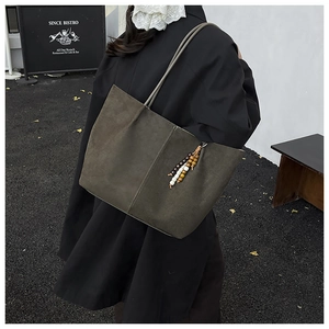 Detail of vintage matte olive green tote bag featuring contrast stitching and wood bead tassel