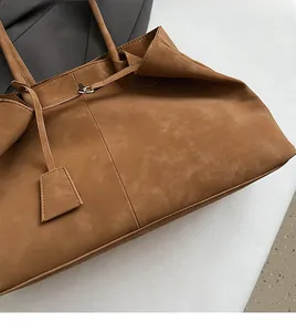 Detailed view of brown matte suede tote bag with slim shoulder strap and silver buckle