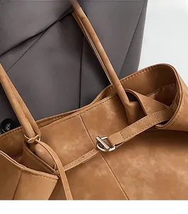 Detailed shot of brown faux leather tote with premium silver buckle and stitching