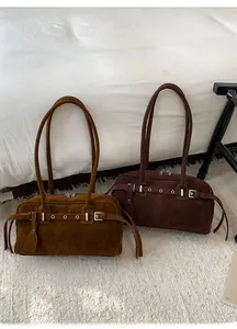 Close-up of vintage Boston bags in caramel and dark coffee with buckled strap details