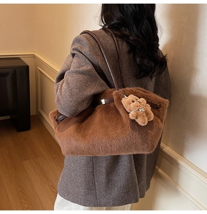Dettaglio borsa tote in ecopelliccia marrone con ciondolo a forma di orsetto e tracolla sottile