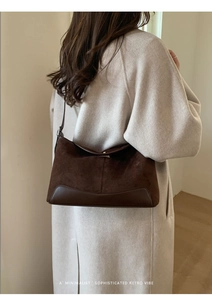 Deep brown suede shoulder bag detail showing premium texture and model styling