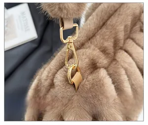 Detail of premium golden metal hook and fluffy faux fur texture on brown cloud bag