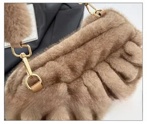 Detail of the brown faux fur cloud bag showing the gold metal clasp and soft plush texture