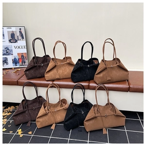 Detail of multi-color suede tote bags in earthy tones with minimalist handle design
