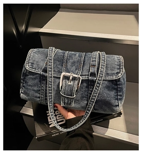Détail du sac Boston en denim vintage avec tissu délavé et boucles métalliques argentées