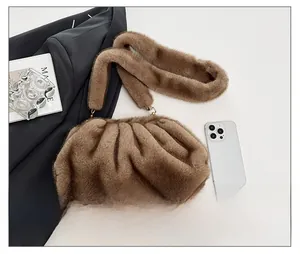 Close-up of brown faux fur pleated cloud bag with soft texture and golden metal hooks