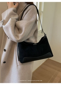Detail of a black retro suede crossbody bag paired with a beige cashmere coat