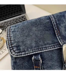 Détail du sac Boston en denim vintage avec coutures orange et boucle en métal argenté