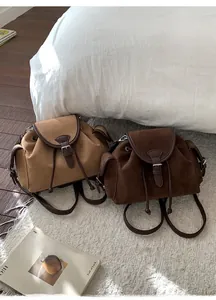Detail of retro suede bucket backpacks in camel and chocolate with drawstring closure
