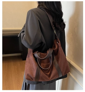 Detail of large brown tote bag showing the soft suede texture and leather handle trim