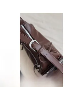 Detailed close-up of the silver metal adjustment buckle on the brown leather strap