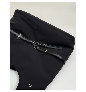 Detail view of premium silver hardware buckle and eyelet strap on black shoulder bag