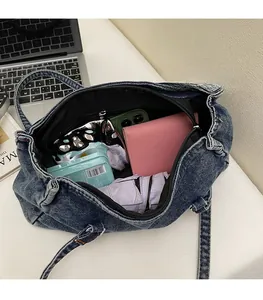 Intérieur spacieux du sac Boston en jean avec portefeuille rose, téléphone et parapluie