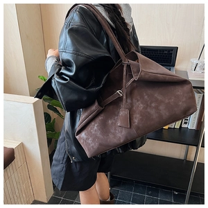 Side view of large brown vintage tote bag with retro texture on female model in a cafe