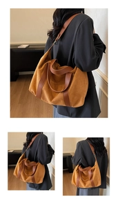 Detail of a large vintage tote bag in tan suede with leather straps on a model
