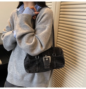Détail d'un sac à bandoulière en denim noir avec boucle argentée au style rétro Y2K