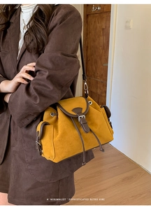 Detail of retro yellow suede crossbody bag with brown leather trim and side pocket