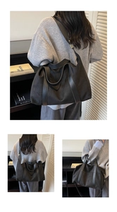 Detail of black tote bag featuring premium leather stitching and spacious interior design