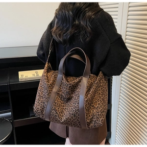 Detail of leopard print tote bag with adjustable shoulder strap shown on a model