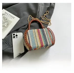 Detailed view of colorful woven handbag with gold rivets and leather trim detailing