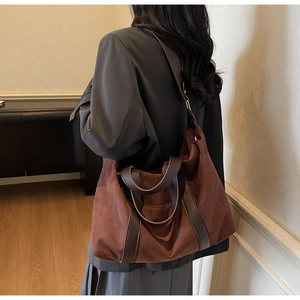 Close-up of large brown suede tote bag showing soft texture and leather shoulder straps