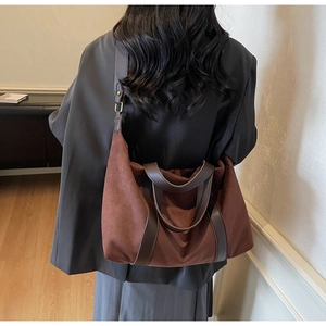 Detailed view of dual-texture brown tote bag with contrast handles and shoulder strap