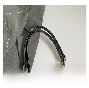 Detailaufnahme des schwarzen Kunstlederriemens mit goldener Metallkette an Leopardenhandtasche