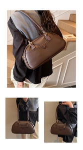 Detailed view of dark brown litchi pattern leather bowling bag with gold hardware accents