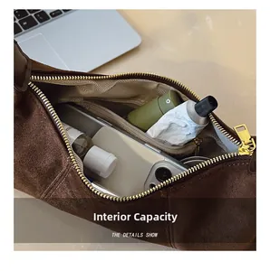 Detail view of large capacity interior with zipper pocket for brown suede underarm bag