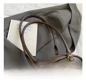 Detail of dark brown leather texture with golden hardware and zipper on a shoulder bag