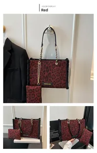 Dettaglio borsa shopper rossa leopardata con catena in metallo ed etichetta moda