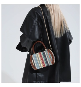 Close-up of colorful striped woven bag with brown leather handles and gold stud details