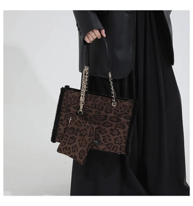 Detail view of leopard print tote bag with black faux fur trim and gold chain strap