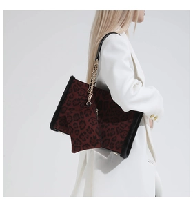 Dettaglio borsa leopardata con bordo in peluche e catena oro su blazer bianco