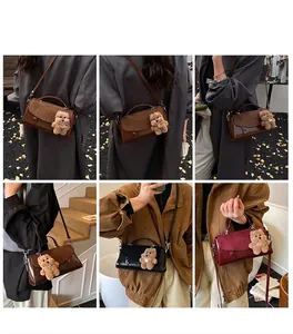 Detailansicht der Vintage-Handtasche mit Plüschbären-Anhänger und verstellbarem Gurt