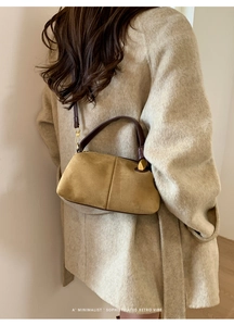 Detail of yellow suede Boston bag with contrast leather handles and gold-tone hardware