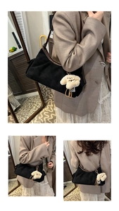 Detail der schwarzen Wildleder-Hobotasche mit braunem Lederbesatz und Welpenanhänger