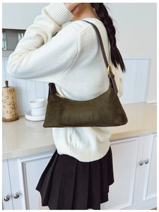 Close-up of olive green suede hobo bag with adjustable brown leather shoulder strap
