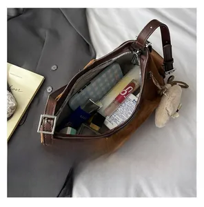 Intérieur spacieux du sac en daim marron avec rangement pour téléphone et cosmétiques