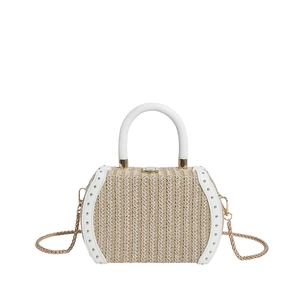 Detail of straw woven bag with white leather trim and gold rivets for beach holiday