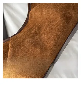 Gros plan sur la texture en daim marron et le liseré en cuir d'un grand sac cabas