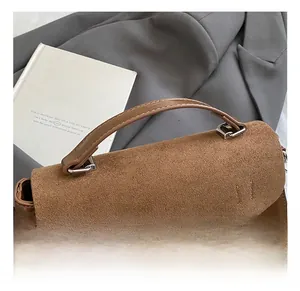 Detailansicht der braunen Leder- und Wildledernähte an einer quadratischen Handtasche