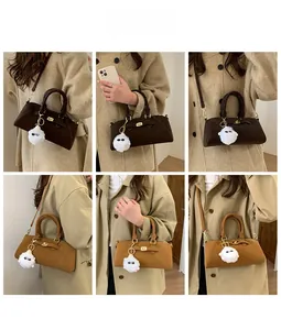 Dettaglio della borsa retrò in pelle con chiusura metallica e ciondolo di peluche