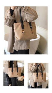 Dettaglio della borsa tote in camoscio kaki con nappe in legno e sottili manici neri